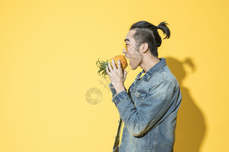 拿着菠萝的青年男性背景图片