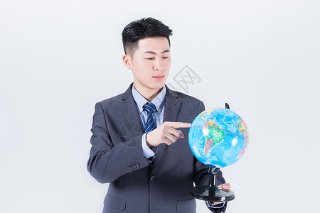 男性手拿地球仪背景图片