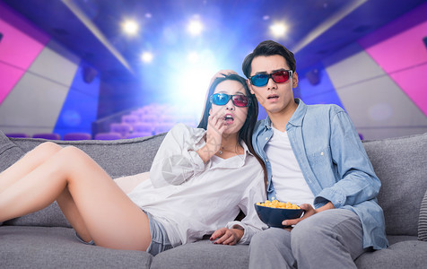 靠着沙发的情侣3D眼镜电影背景设计图片