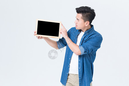 年轻男性手拿空白小黑板展示背景图片