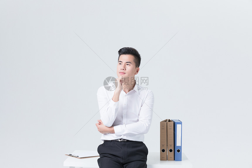 坐在办公桌上思考的商务男性图片