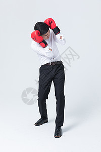 商务男士戴拳击手套抱头高清图片