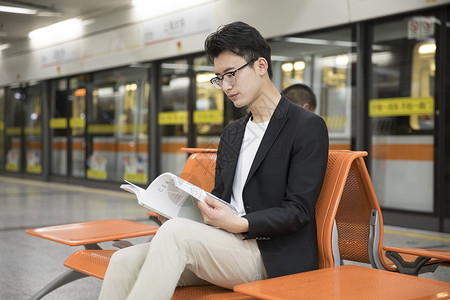 上班男生商务男士在地铁里阅读背景