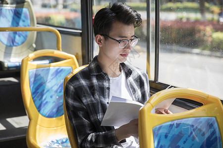 学生在公交上看书阅读拜读高清图片素材