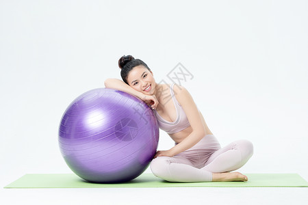 年轻女性瑜伽球瑜伽背景图片
