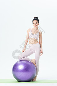 年轻女性瑜伽球瑜伽背景图片
