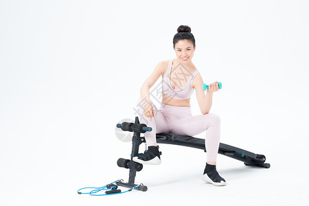 坐在仰卧板上锻炼的运动女性图片