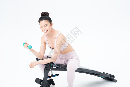 坐在仰卧板上锻炼的运动女性背景图片