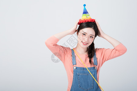 戴着生日帽微笑庆祝的青年女性背景