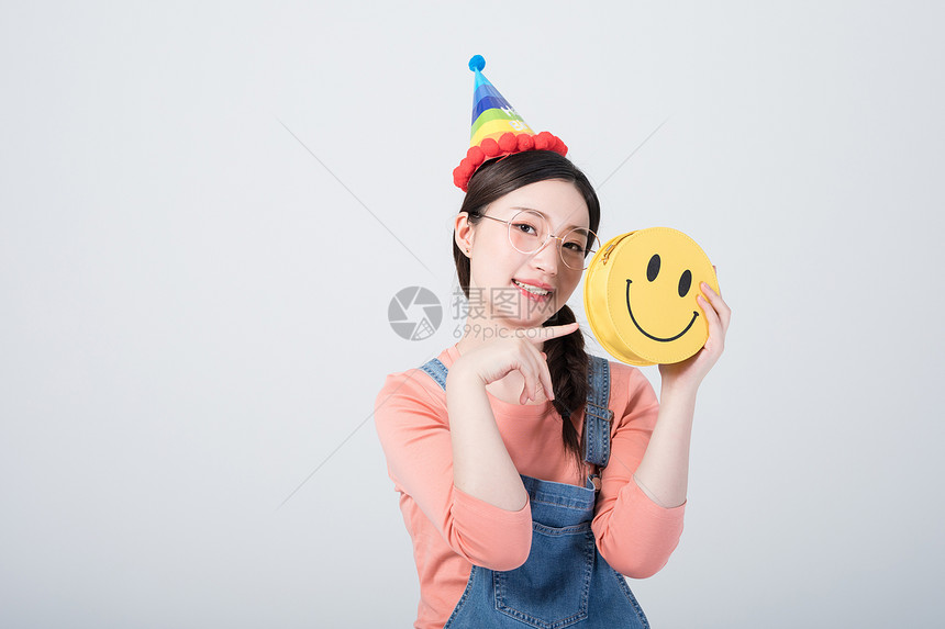 戴着生日帽微笑庆祝的青年女性图片
