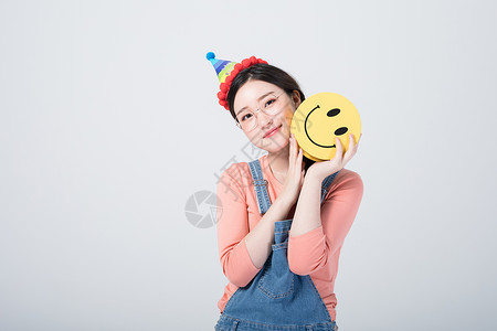 戴着生日帽微笑庆祝的青年女性高清图片