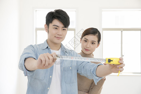 测量房子的情侣背景图片