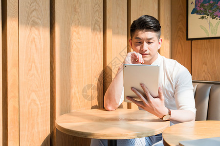 咖啡馆休闲放松使用平板电脑的年轻男性图片