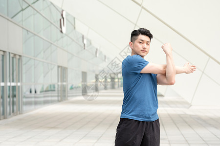 年轻男性户外运动热身拉伸动作图片