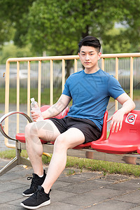 运动后坐着休息喝水放松的年轻男性高清图片