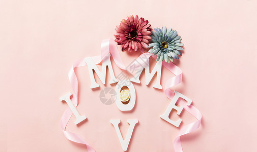 粉色背景上的MOM字母鲜花背景图片