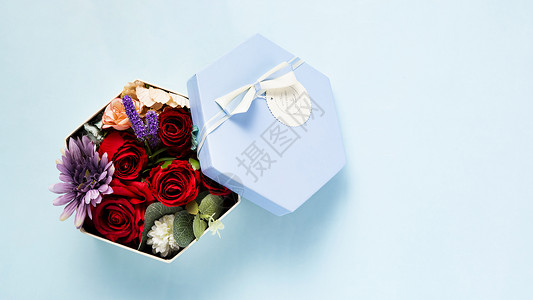 蓝色背景上装满鲜花的礼物盒背景
