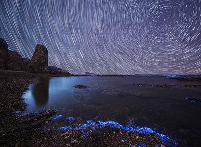 荧光海滩下的星轨背景图片