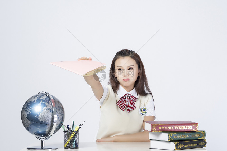 拿着作业本的学习的女学生图片