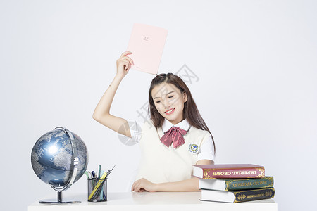 拿着作业本的学习的女学生图片