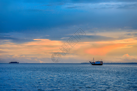 马来西亚花夕阳大海与渔船背景