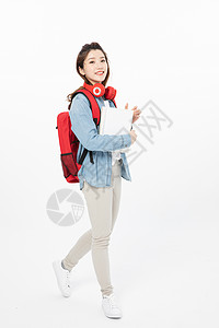 行走中背书包戴耳机的女大学生图片