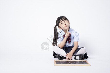 黑板前思考在动脑经的拿着黑板的小女孩背景