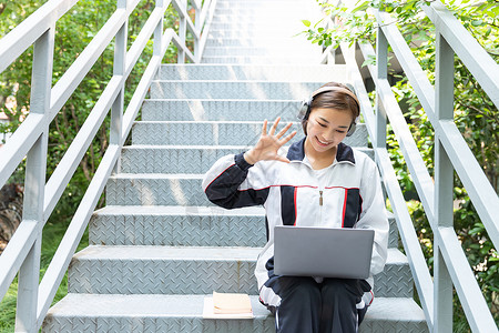 跪着招手的女孩高中生校园楼梯在线教育背景