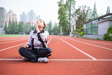 运动校服高中生在操场运动休息喝水背景