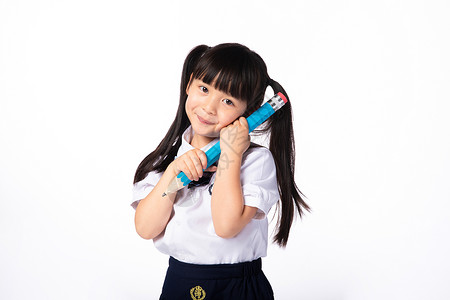 抱着铅笔女孩抱着铅笔的穿校服的小女孩背景