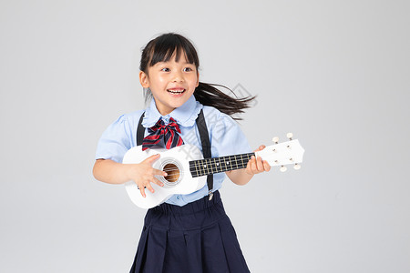 弹吉他学生开心的弹尤克里里的小女孩背景