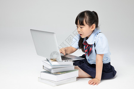 坐着使用电脑的小女孩高清图片