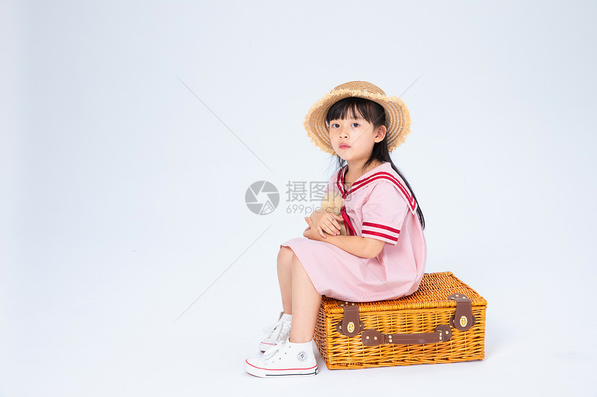 坐在旅行箱上的小女孩图片
