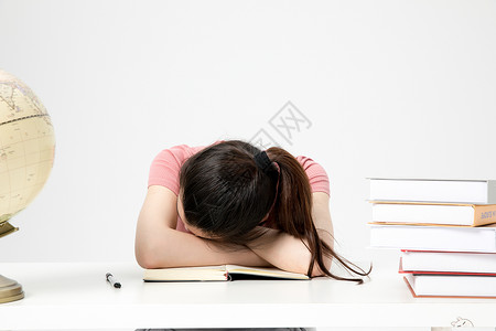 睡觉地球青年女性学生课桌上睡觉休息背景