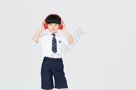 儿童男生戴着耳机听音乐跳舞背景图片