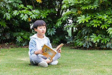 可爱儿童草地上看书模特高清图片素材