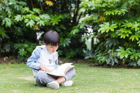 可爱儿童草地上看书高清图片
