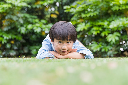 可爱儿童开心趴在草地上图片