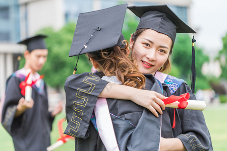 毕业季同学穿学士服拥抱告别背景图片