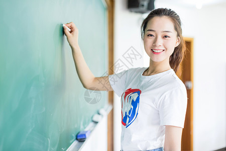 黑板前拿粉笔写字的女生大学高清图片素材