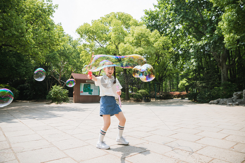 公园里可爱女孩玩吹泡泡图片
