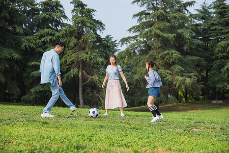 一家人草地上踢足球高清图片