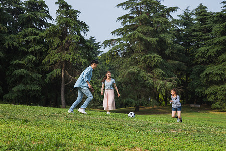 一家人草地上踢足球高清图片