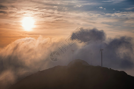 日出科技黄昏时山顶云海中的发电风机背景