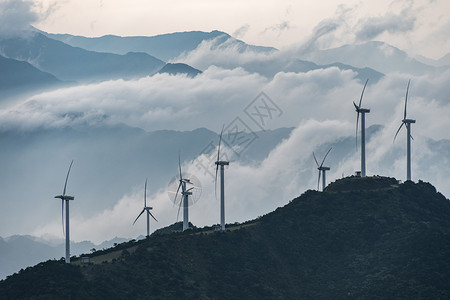 山顶云海中的发电风车背景图片