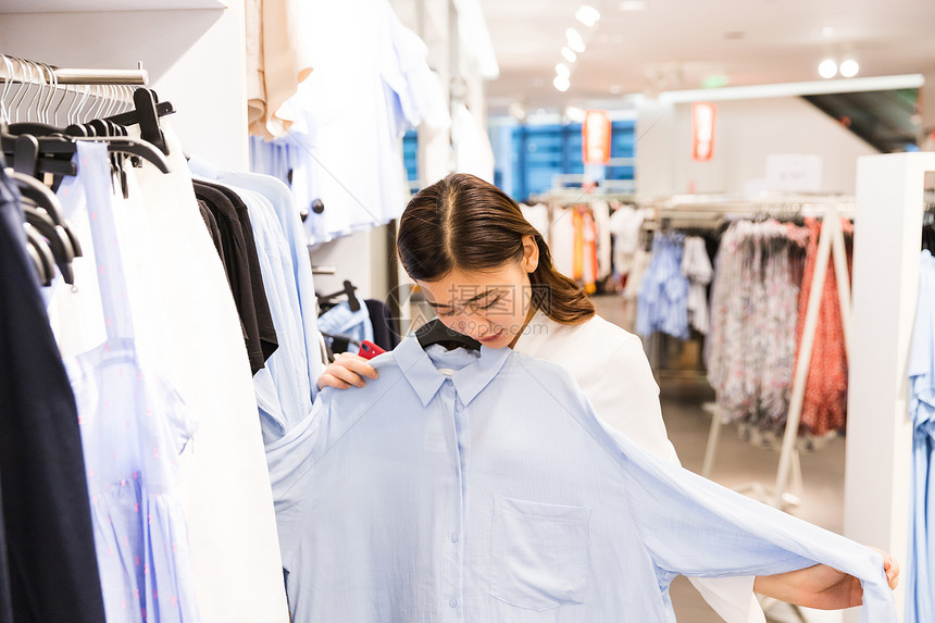 青年女性女装店挑选衣服图片