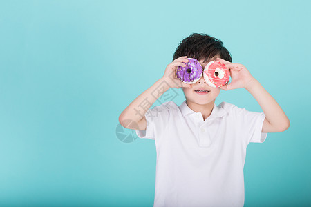 甜甜圈男孩儿童小男孩手持甜甜圈玩耍背景