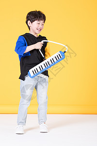 儿童小男孩手持玩具口风琴玩耍背景图片