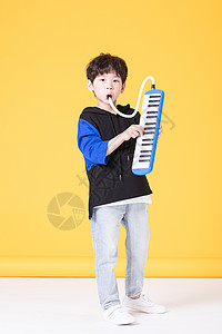 儿童小男孩手持玩具口风琴玩耍背景图片