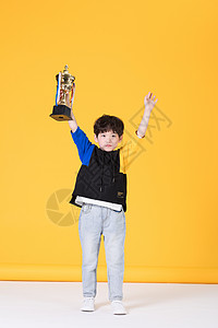 儿童小男孩手持奖杯童年生活背景